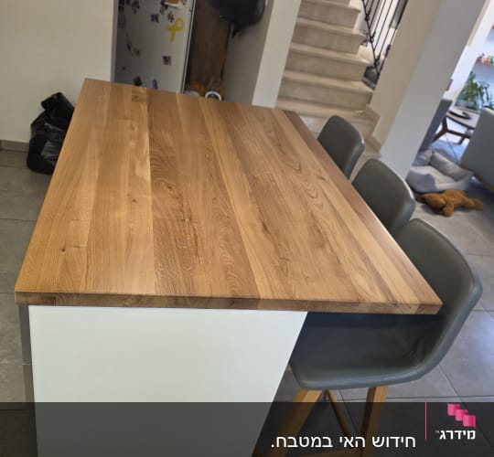 אי מטבח עם כיסאות עץ ורצפת אריחים